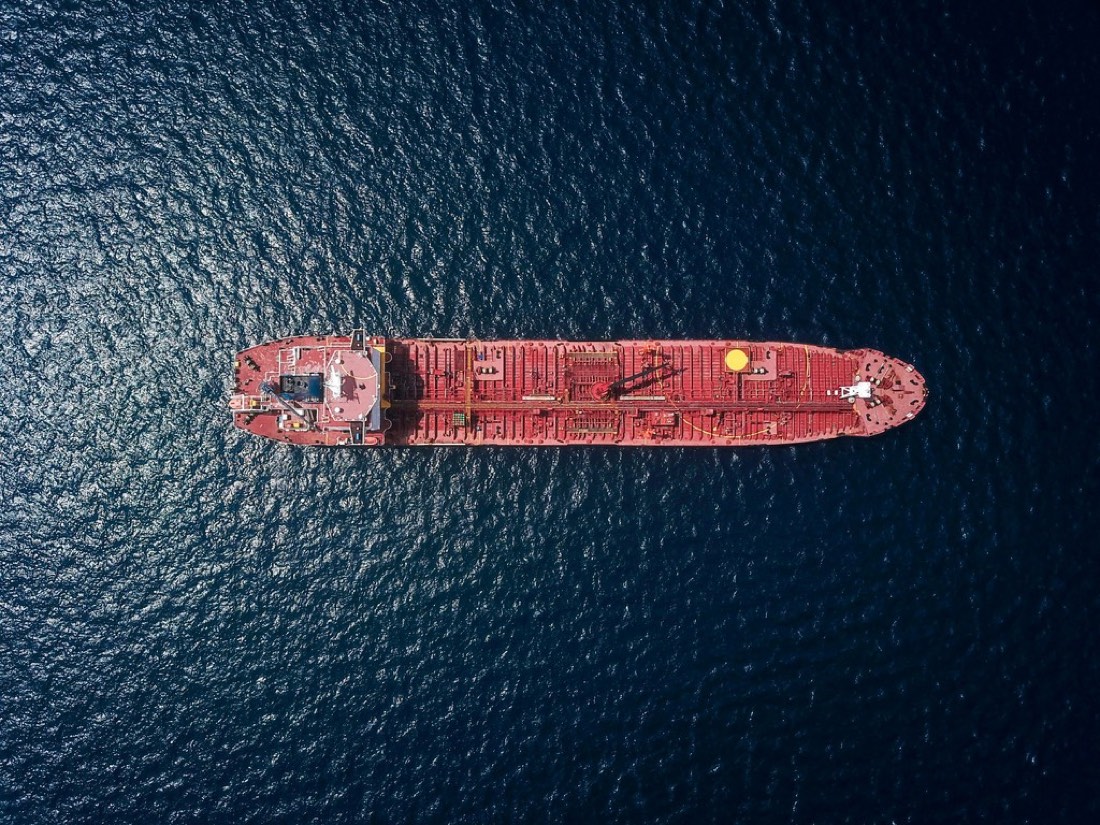Red container ship under way